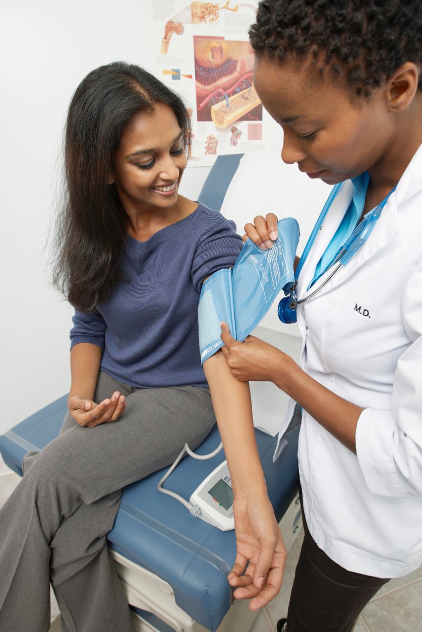 female doctor checking patient's blood pressure